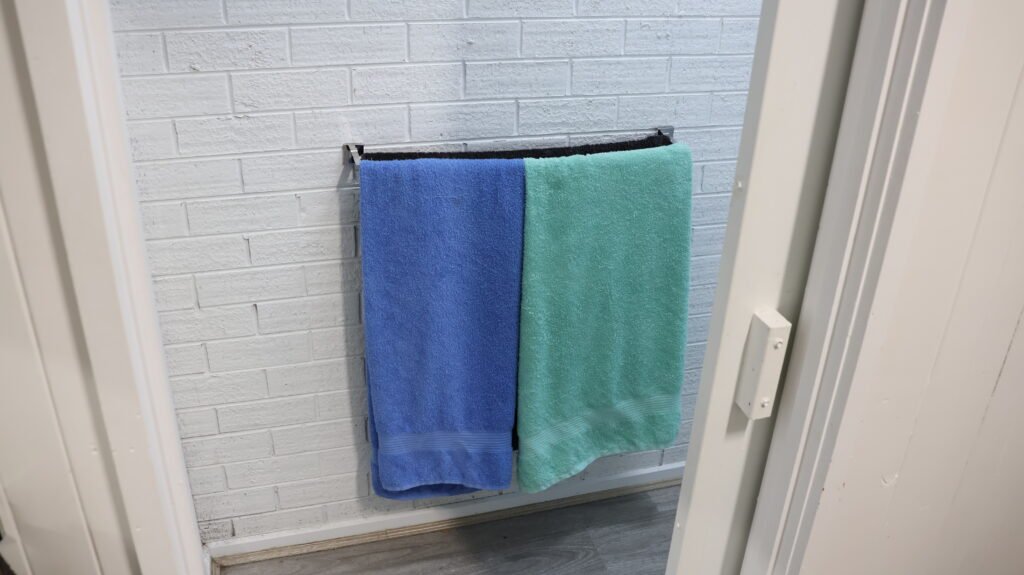 Two towels hanging on a bathroom towel rail