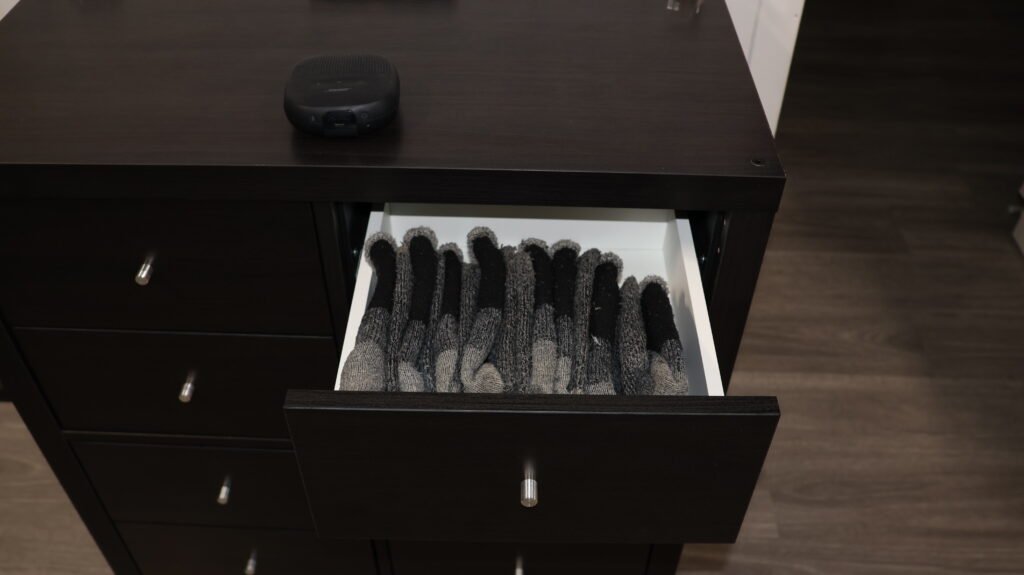 An open bedroom drawer with socks standing upright in neat rows
